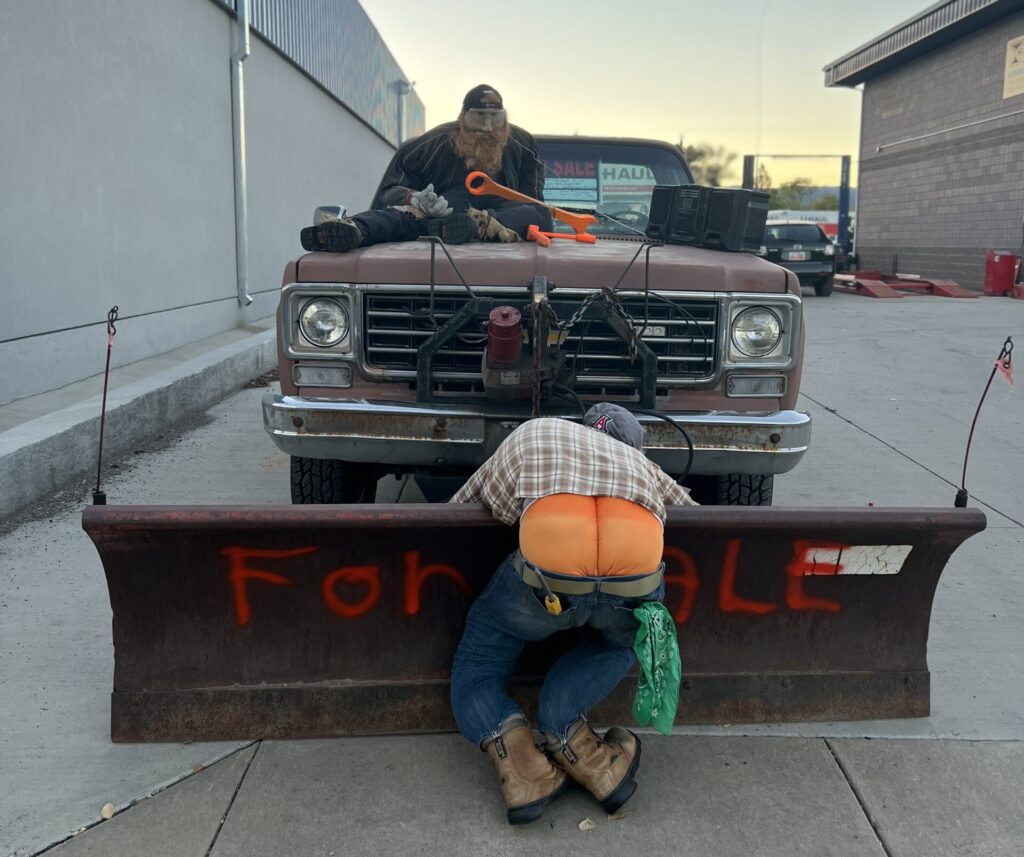 scarecrow repairing a car