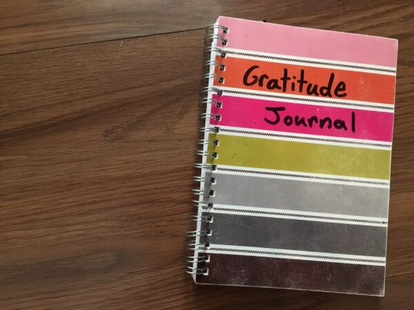 A notebook with the words, "gratitude journal" written on it.