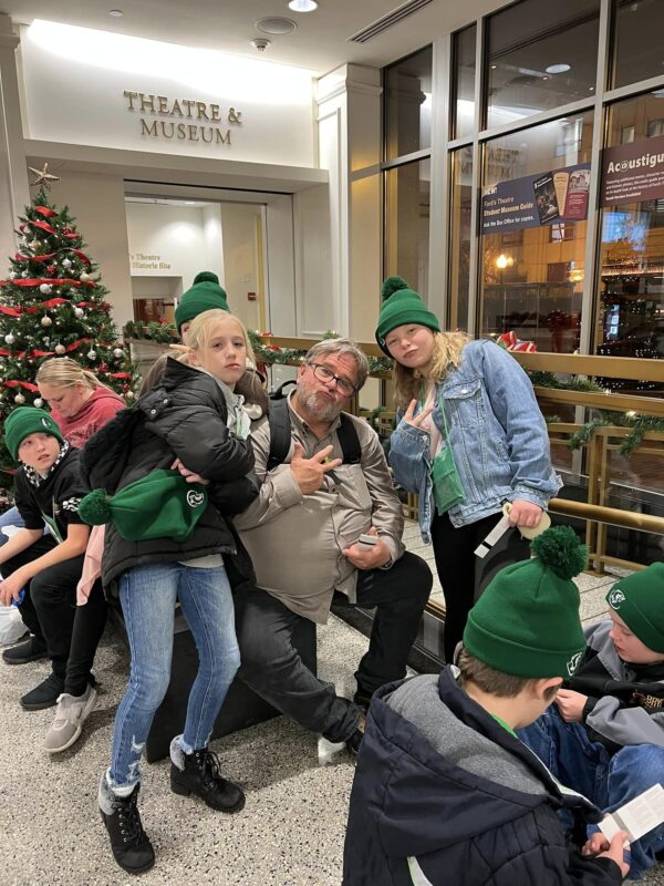 Mr. Peterson poses with some of 6th grade girls waiting outside ford's theatre.
