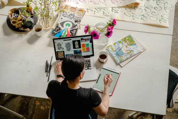 Gen Zer using a laptop and art supplies.