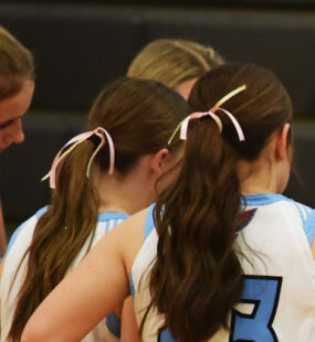 Pink ribbons in the basketball players' ponytails in honor of Jacqueline.