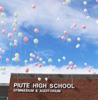 Balloons float off into the sky outside Piute High School.