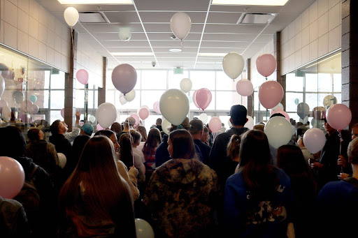 Piute's students hold pink and green balloons.