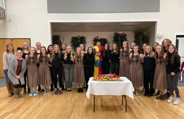 Piute's choir poses with their jester and tradition yule feast food.