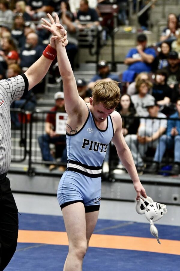 Ref holds McKray's arm up to signify his win after his fourth state championship.