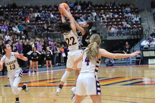 Number 22 jumps to catch the ball before the other team gets it.