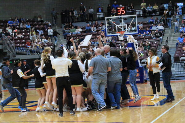 Wayne basketball team and cheerleaders celebrate their trophy.