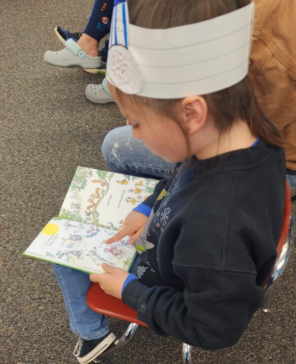 A little girl reading a Dr. Seuss book.