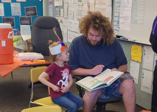 A man and child reading "The Sneetches" together.