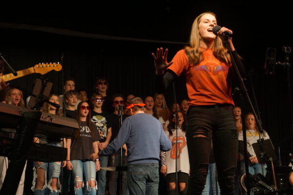 Soloist Katie Snyder belts "Seperate Ways" by Journey with the choir as back up vocals.