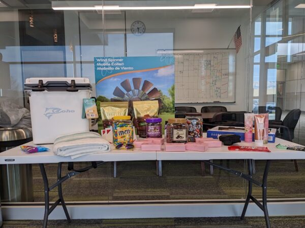 Bags and bars of candy, a cooler, and a blanket on a prize table.