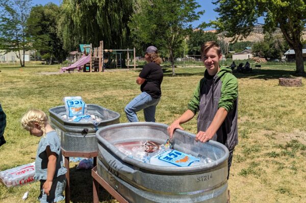 Two junior boys man the drinks coolers for lunch.