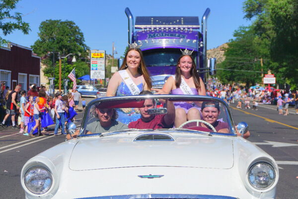 Miss Garfield and her outstanding teen ride in an old car during a parade down main street.