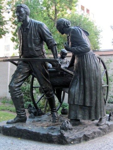 Statue of a pioneer man and woman pulling a handcart.