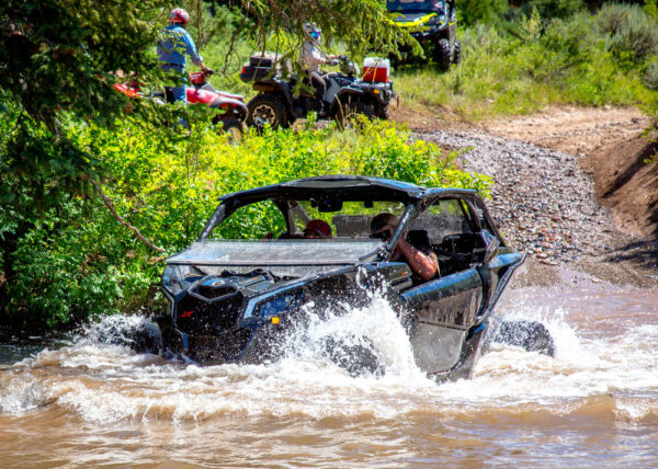 An OHV (off-highway vehicle) drives into a stream of water.