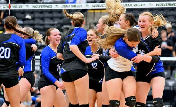 The Panguitch volleyball team cheers and hugs after their state championship win.