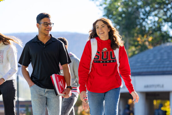 A young man and a young woman walk onto campus at SUU.