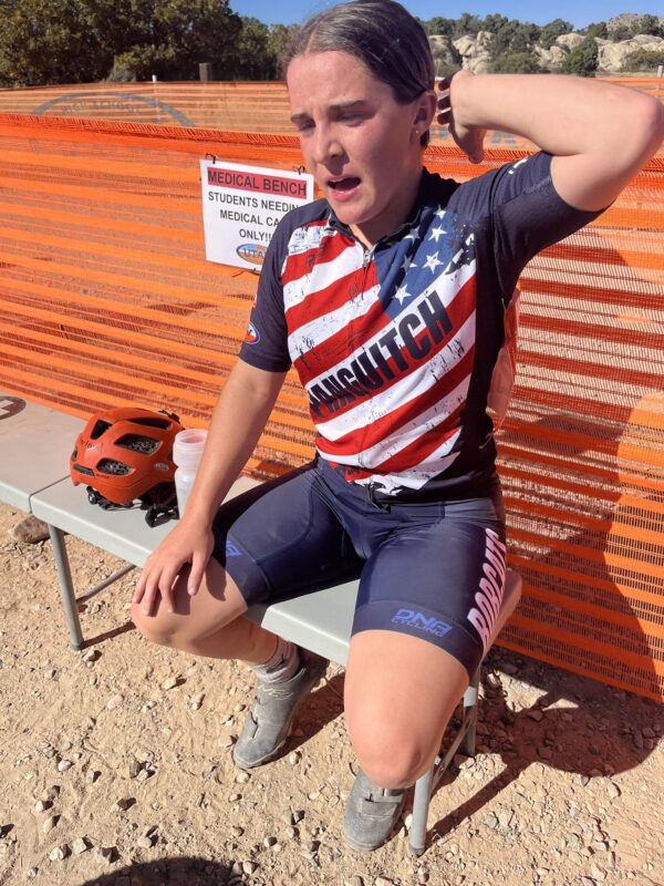 Kadee Harland sits down, red-faced and tired, right after finishing the mountain biking race.