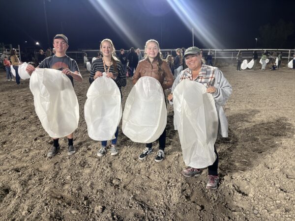 Four people showing off their lanterns before they were lit.