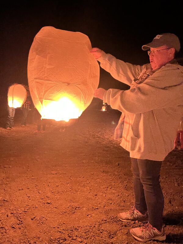 A person lighting floating lantern.