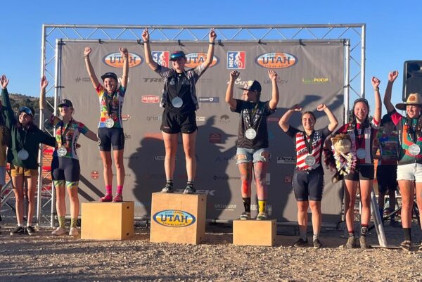 An outside podium, with Kadee Harland celebrating in the #5 position. All competitors are wearing medals.