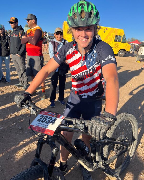 Ronan Mooney grinning with his bike as he gets ready to race.