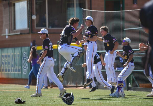 Wayne baseball players jumping high in the air as they return from the field celebrating.