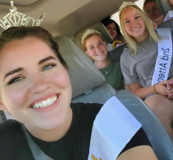 Miss Garfield (2024) takes a picture in the car with her attendants.
