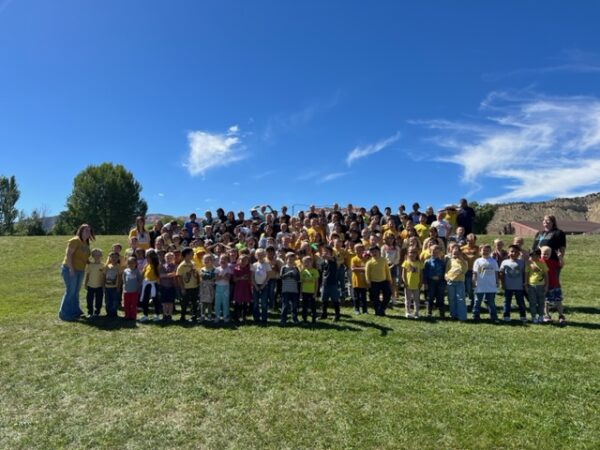 The whole of Bryce Valley Elementary School stands outside in their gold shirts for a picture.