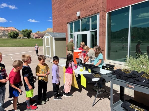 Kids stand in line for a lemonade stand.