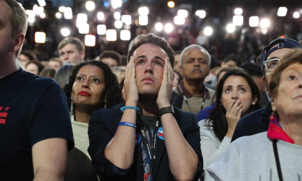 A crowd of Hillary Clinton fans stares up in worry and despair.