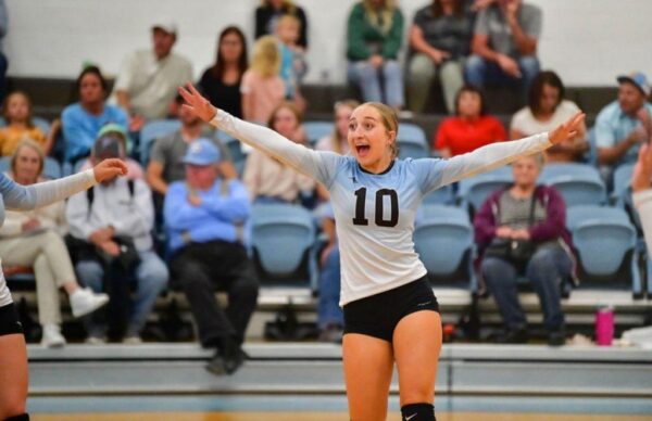 A Piute volleyball player holds her hands out in excitement after making a point.