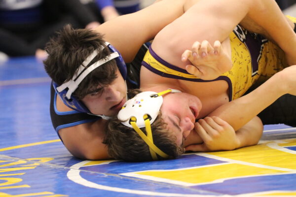 A Panguitch wrestler holds a Wayne wrestler under the armpits as he tries to roll him into a pin.