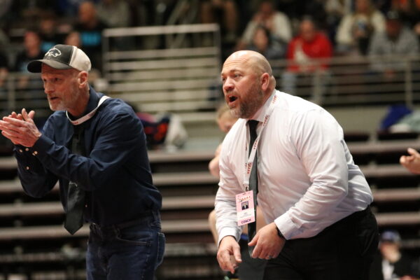 Panguitch wrestling coaches cheer on their wrestlers on the mat.