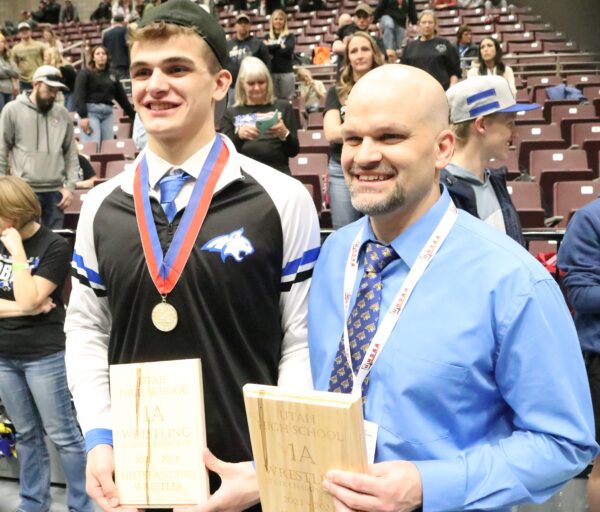 Jacob Marshall and dad/coach Colin Marshall hold up their awards for outstanding wrestler and 1A coach of the year.
