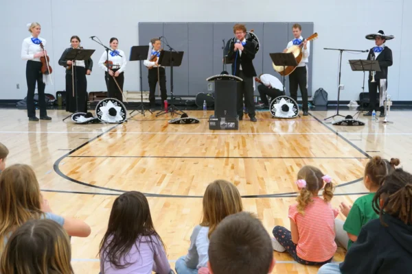 BYU's mariachi band playing in Escalante's school gym while elementary schoolers look on.