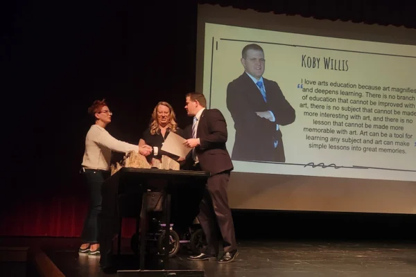 Superintendent Koby Willis accepts an award on stage.