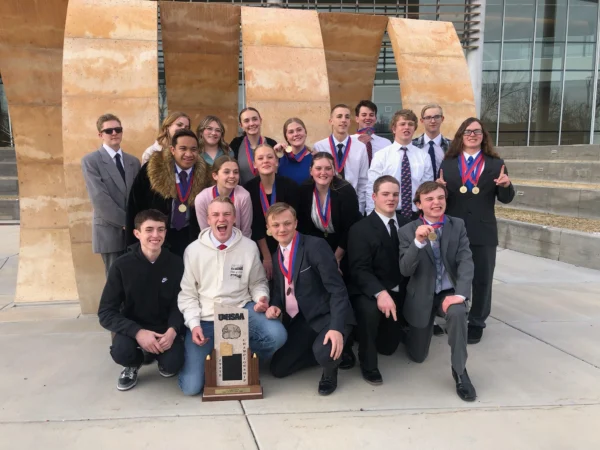 Group picture of Panguitch's debate team with their first place state trophy.