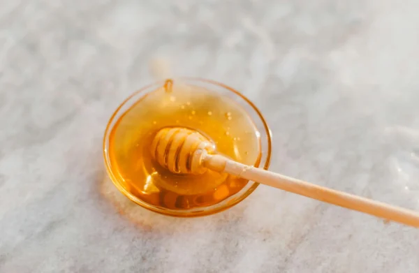 A bowl of honey with a honey dipper.