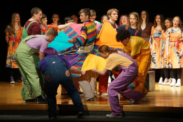 The brothers spread out Joseph's coat and examine its bright colors.