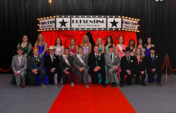 Piute's junior class posing for a group picture on the red carpet in front of the Hollywood-themed sign reading "Piute High class of 2025, presenting Junior Prom 2024."