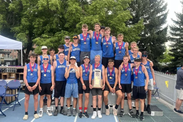 The Panguitch boys track team holding their state trophy on BYU's track.