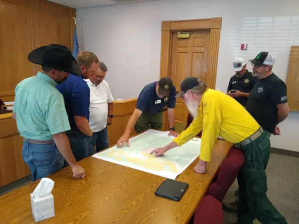 Piute County Commissioners gather around a map of the Silver King Fire, which is located near Marysvale.