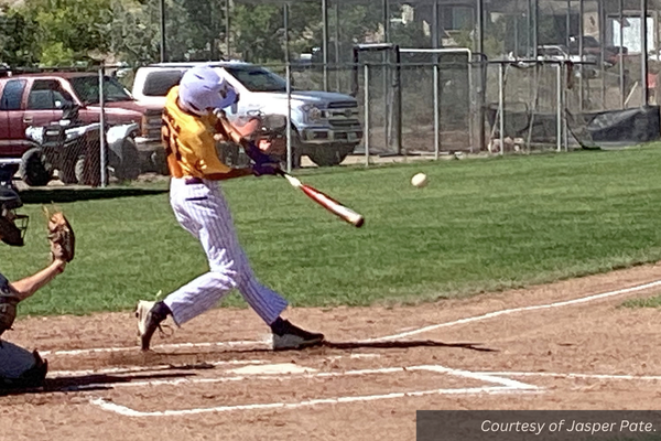 A Wayne baseball player up to bat hits the baseball. Courtesy of Jasper Pate.