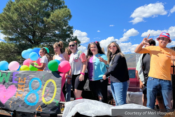 Piute's 80s float with high schoolers dressed in bright colors and crimped hair. Courtesy of Meri Vasquez.