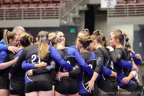 The Panguitch volleyball team in a huddle together.