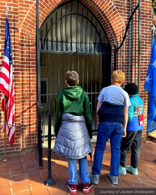 Three kids peek into a gated structure at Mount Vernon. Courtesy of Jayleen Shakespear.