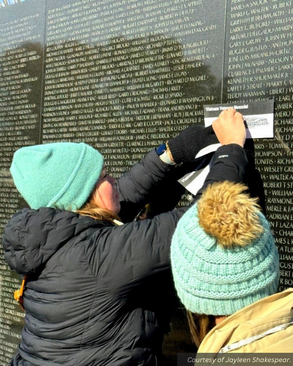 A woman takes a name rubbing from a monument. Courtesy of Jayleen Shakespear.