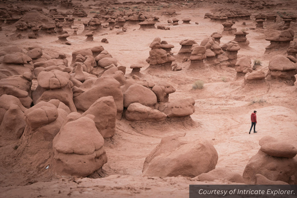 A solitary person exploring the stacked pinkish rocks in Goblin Valley State Park, Utah. Courtesy of Intricate Explorer.