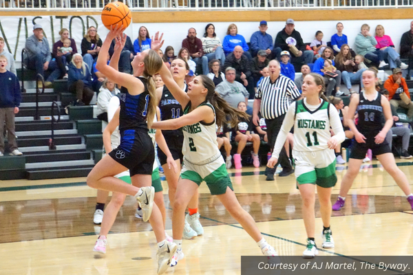 A Panguitch girls basketball player, surrounded by Bryce Valley players, goes in for a layup.